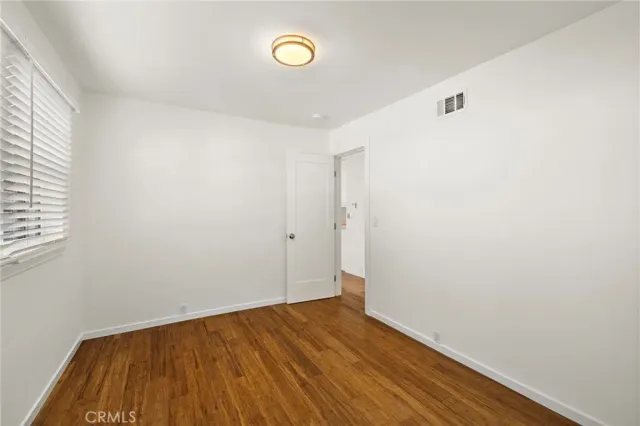 a view of a room with wooden floor and white walls