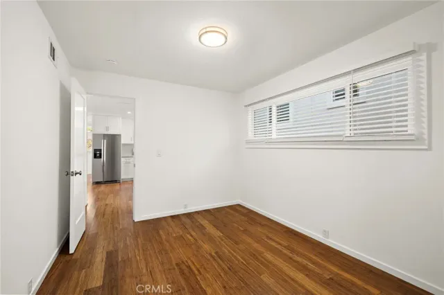 a view of a room with wooden floor and a ceiling fan