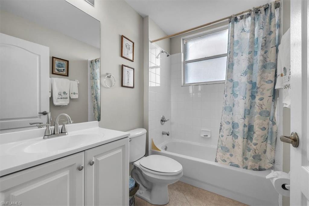 8075 Tiger Cove, Unit 1706 Naples, FL 34113 - Photo 25 of 50 Full bathroom with shower / tub combo with curtain, vanity, and light tile patterned flooring