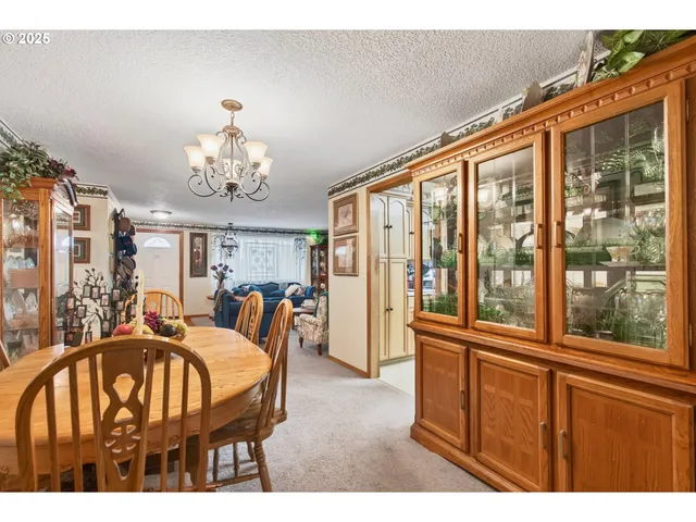 a view of a dining room with furniture a chandelier and large windows