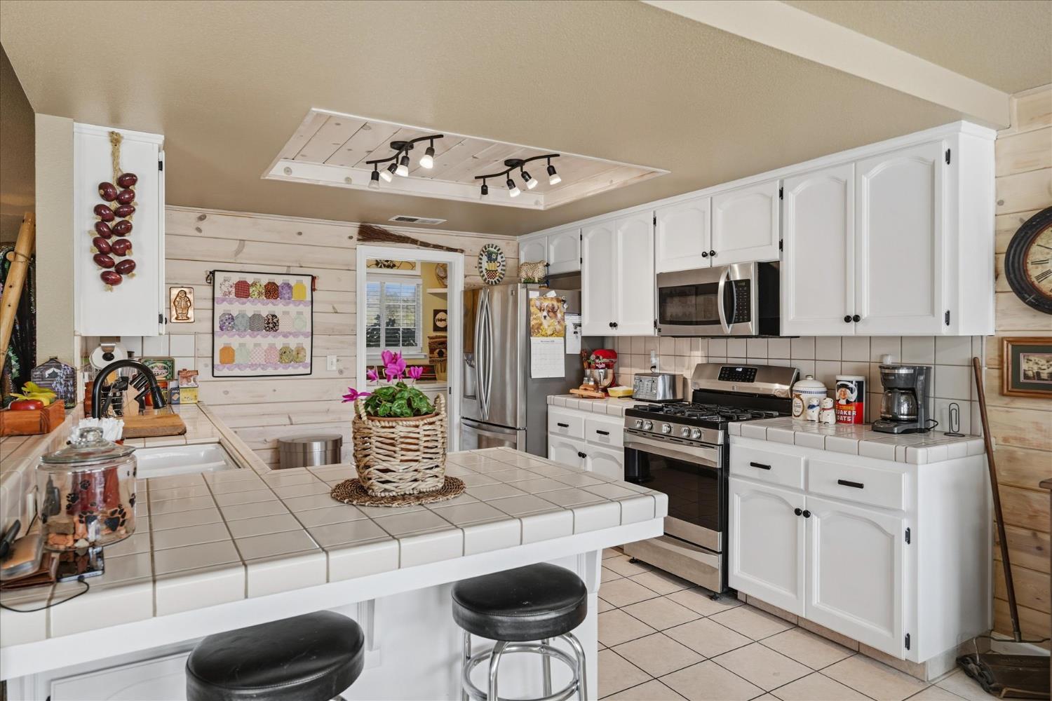 32583 River Knolls Road Coarsegold, CA 93614 - Photo 20 of 63 a kitchen with stainless steel appliances kitchen island granite countertop a stove a sink dishwasher and a dining table with wooden floor