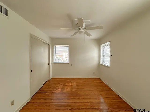 a view of empty room with wooden floor