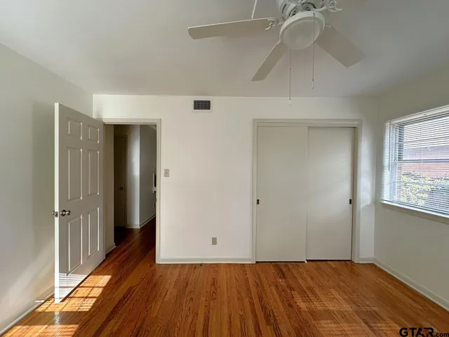 a view of an empty room with wooden floor