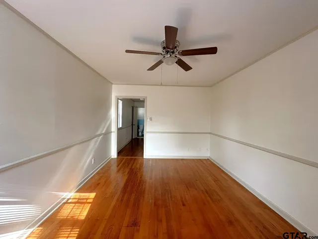 a view of empty room with wooden floor