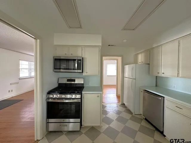 a kitchen with stainless steel appliances a stove a microwave and a sink
