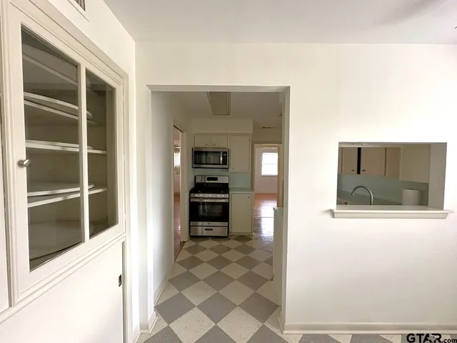 a view of a hallway with wooden floor and windows