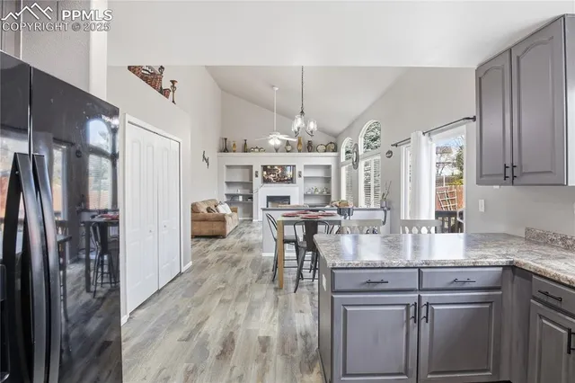 a kitchen with kitchen island granite countertop lots of counter top space and wooden floor