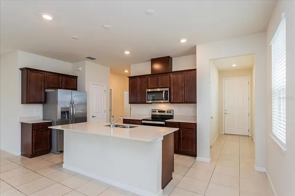 a kitchen with stainless steel appliances a stove top oven a sink a refrigerator and a microwave