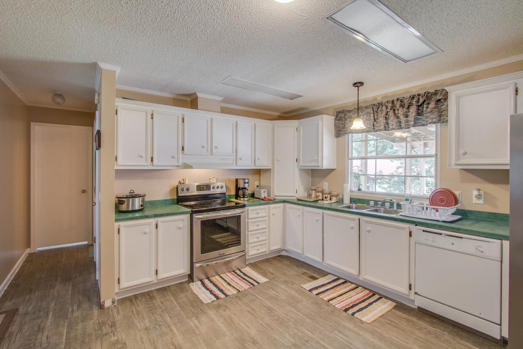 4035 Rock Springs Road Watertown, TN 37184 - Photo 9 of 26 a kitchen with granite countertop white cabinets and white appliances