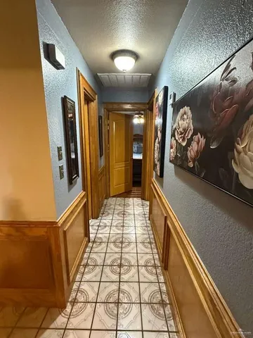 a hallway with beautiful frames and rug