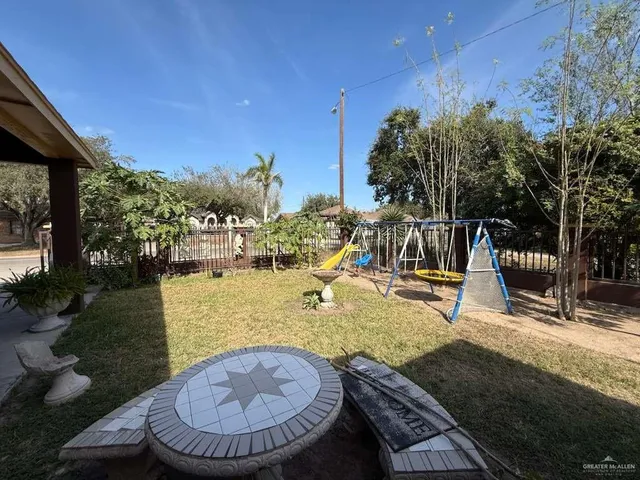 a view of a patio with table and chairs potted plants and floor to ceiling window