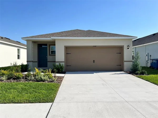 a front view of a house with a yard and garage