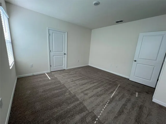 an empty room with wooden floor and window