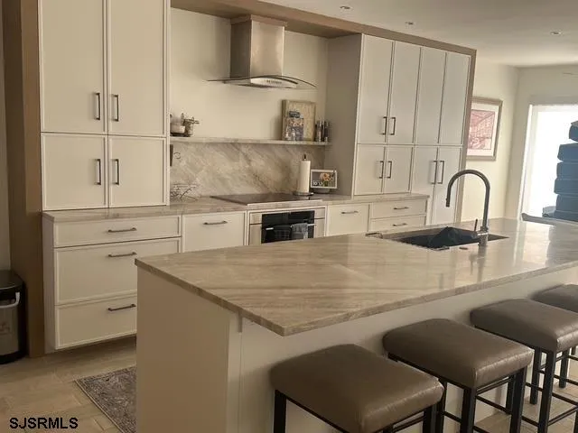 a kitchen with a stove a sink and a refrigerator with white cabinets