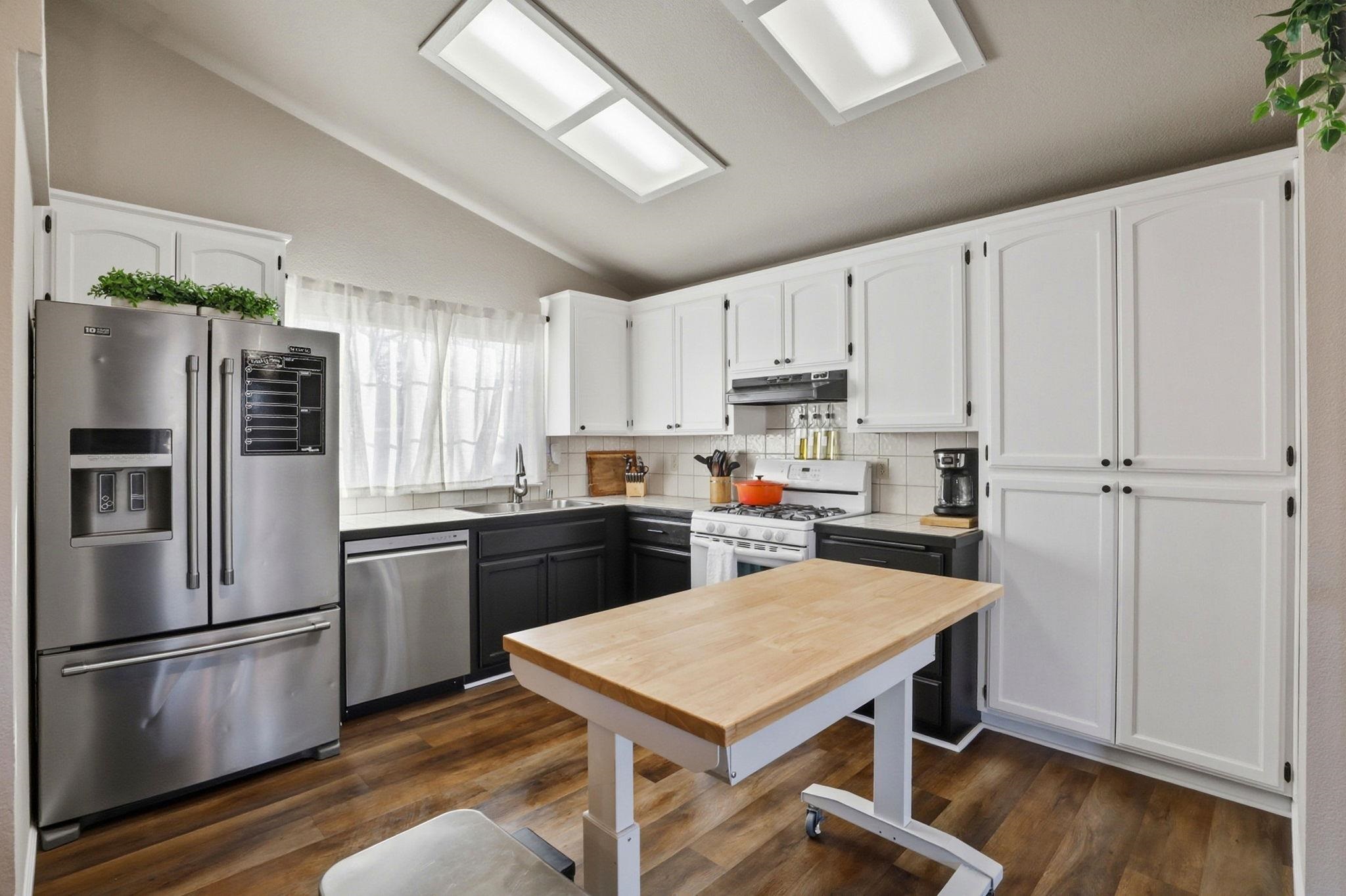 799 Morgans Ranch Circle Galt, CA 95632 - Photo 11 of 36 Dual tone kitchen with stainless steel appliances, backsplash, dark wood-type flooring, vaulted ceiling, and two tone cabinets