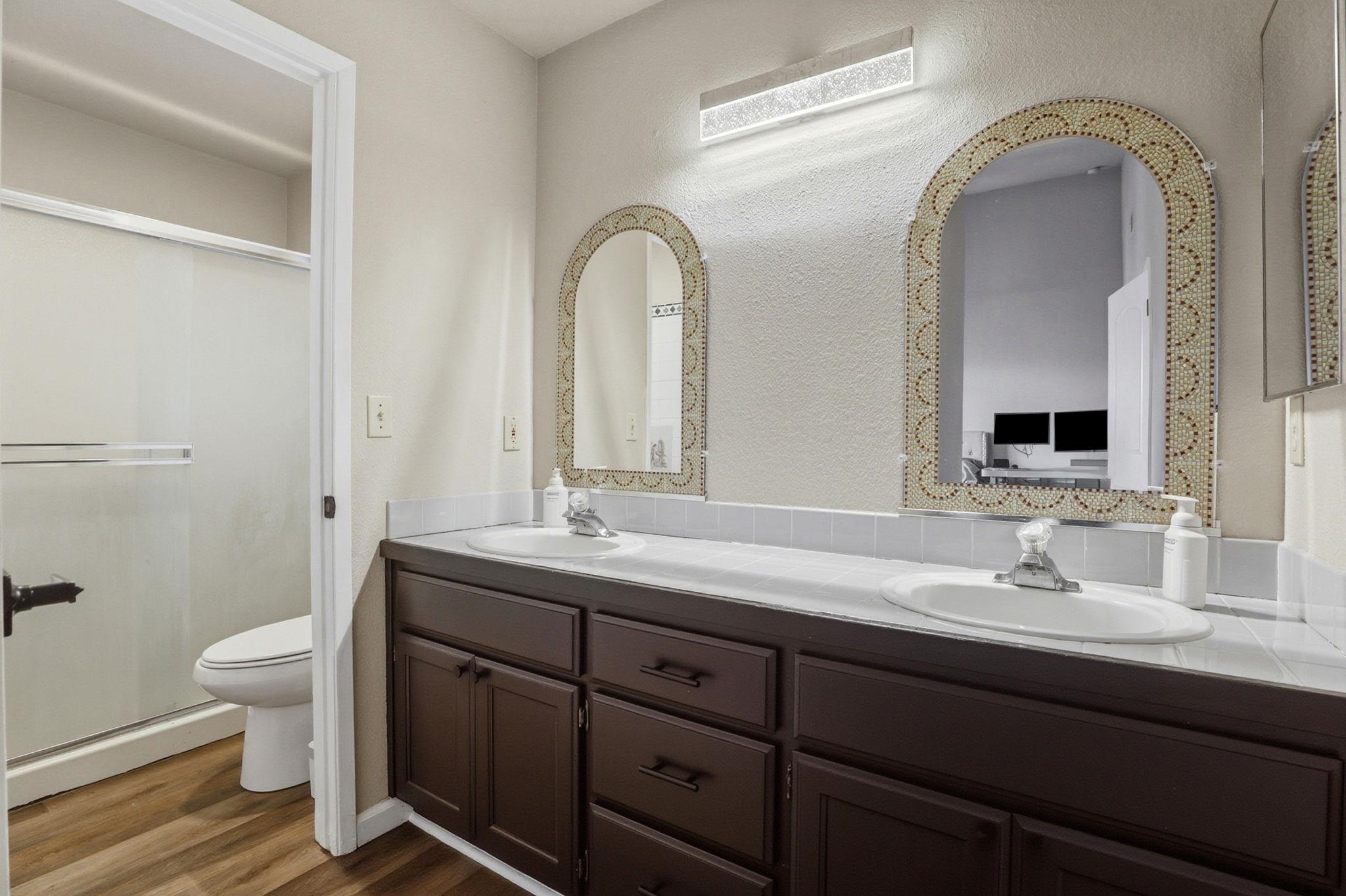 799 Morgans Ranch Circle Galt, CA 95632 - Photo 27 of 36 Bathroom with double vanity, a textured wall, and dark wood-style flooring