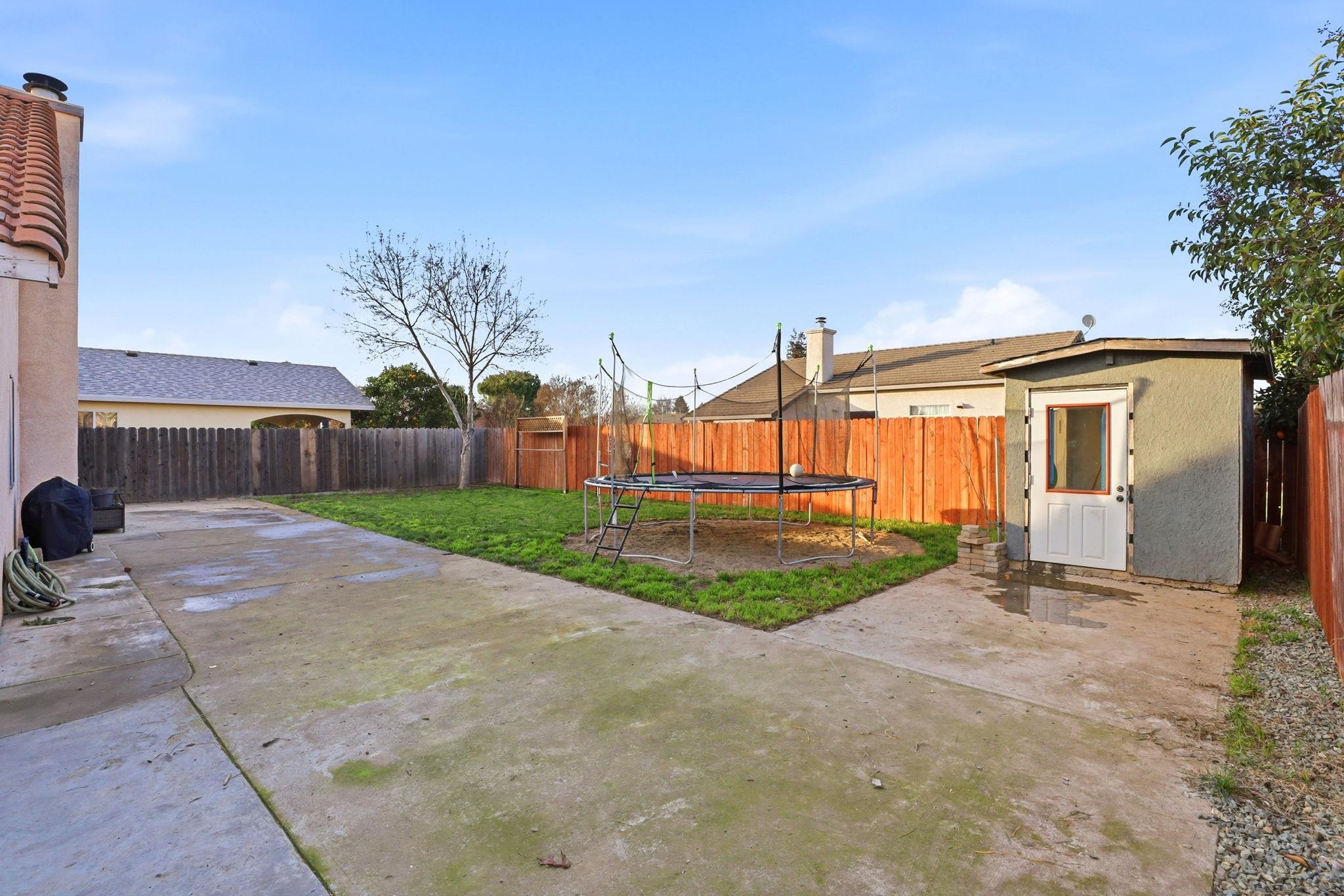 799 Morgans Ranch Circle Galt, CA 95632 - Photo 30 of 36 Fenced backyard featuring a storage shed, a patio area, and a trampoline