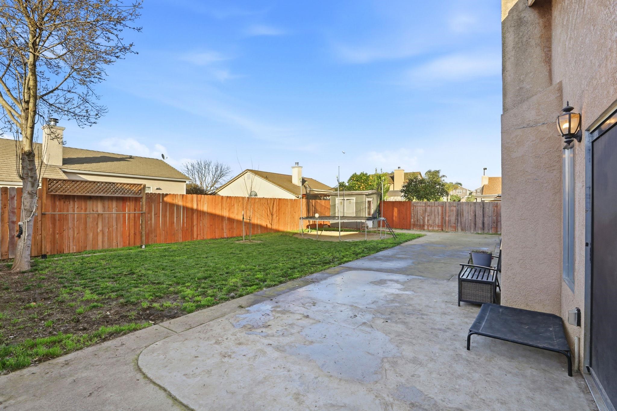 799 Morgans Ranch Circle Galt, CA 95632 - Photo 31 of 36 Fenced backyard featuring a trampoline and a patio area