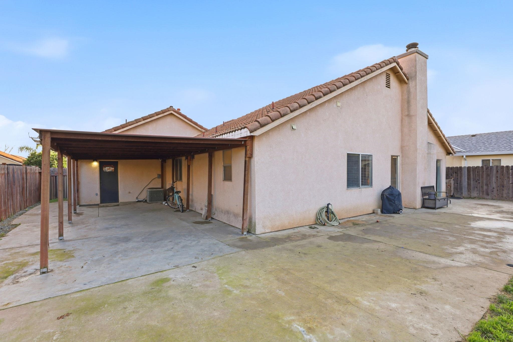 799 Morgans Ranch Circle Galt, CA 95632 - Photo 33 of 36 Back of house featuring a fenced backyard, stucco siding, a chimney, and a patio area