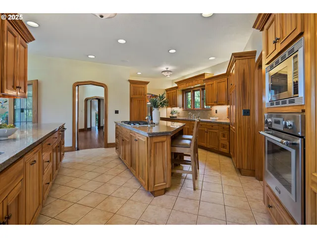 a kitchen with stainless steel appliances granite countertop a refrigerator and a stove top oven