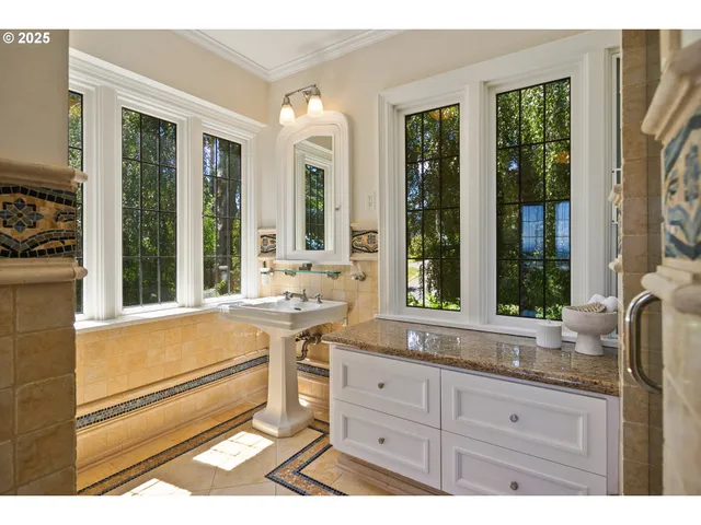 a spacious bathroom with a granite countertop tub and a large window
