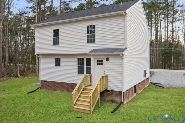 a view of a white house with a yard and wooden fence