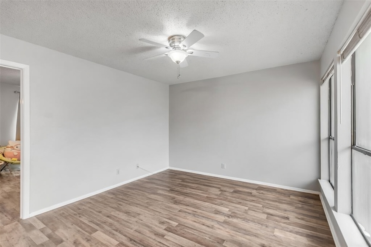 3115 Helms Street, Unit 210 Austin, TX 78705 - Photo 16 of 17 a view of a room with wooden floor and a ceiling fan