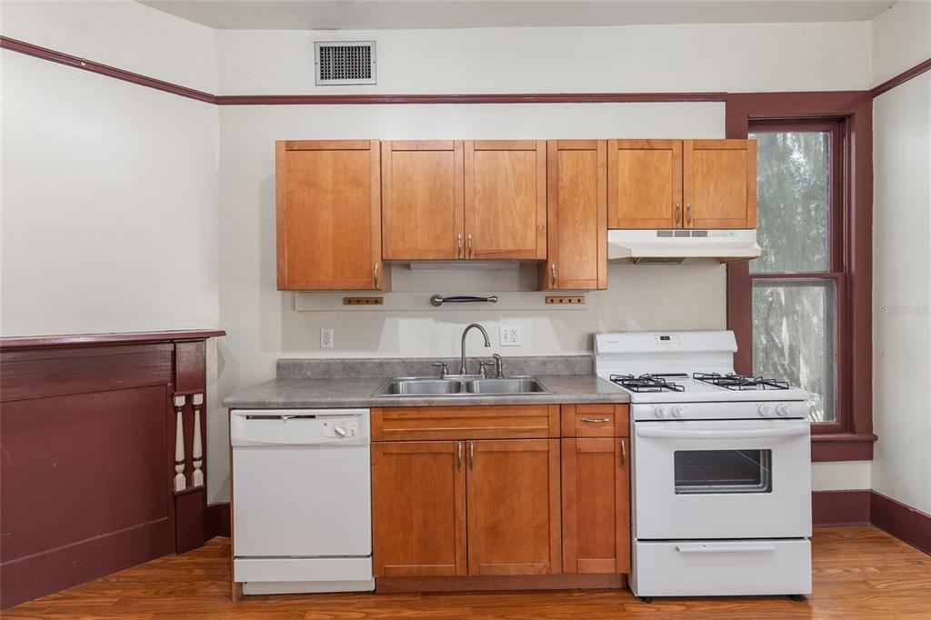 306 Northeast 3rd Street Gainesville, FL 32601 - Photo 24 of 88 a kitchen with a stove top oven sink and cabinets