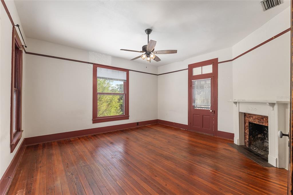 306 Northeast 3rd Street Gainesville, FL 32601 - Photo 29 of 88 a view of an empty room with wooden floor fireplace and a window
