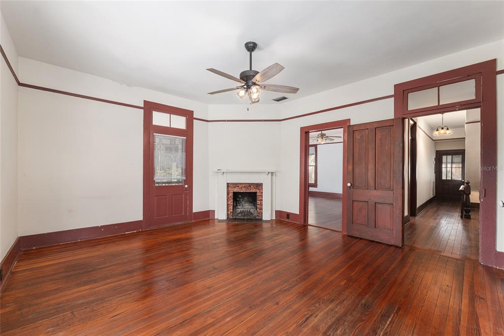 306 Northeast 3rd Street Gainesville, FL 32601 - Photo 30 of 88 a view of empty room with wooden floor fireplace and window