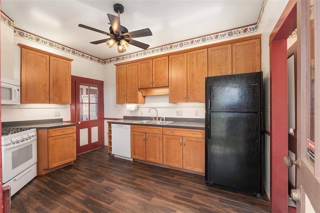 306 Northeast 3rd Street Gainesville, FL 32601 - Photo 46 of 88 a kitchen with stainless steel appliances granite countertop a refrigerator a sink and white cabinets