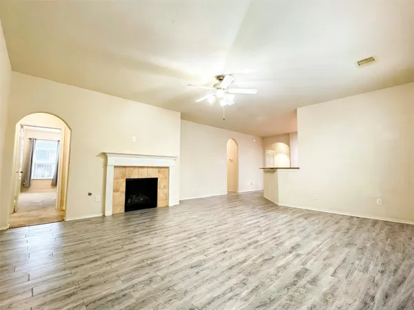 a view of empty room with wooden floor and fireplace