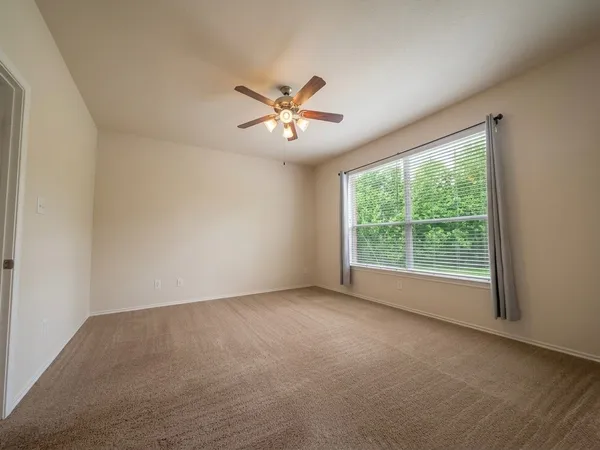 a view of room with a ceiling fan and window