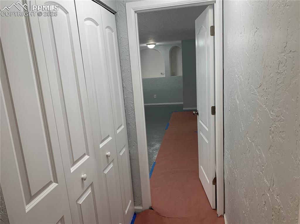 1057 Peterson Road Colorado Springs, CO 80915 - Photo 20 of 32 Corridor with a textured wall and arched walkways