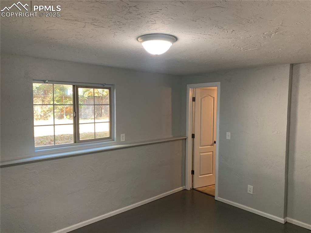 1057 Peterson Road Colorado Springs, CO 80915 - Photo 25 of 32 Spare room featuring a textured ceiling and a textured wall