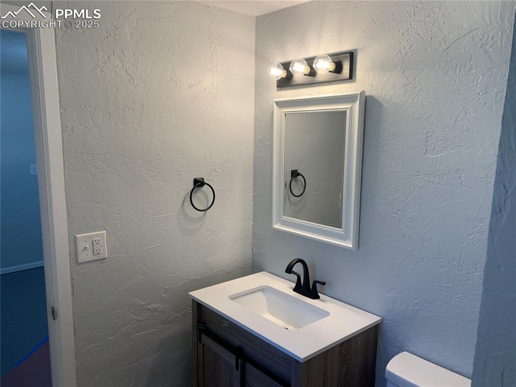 1057 Peterson Road Colorado Springs, CO 80915 - Photo 27 of 32 3/4 bathroom with a textured wall and vanity