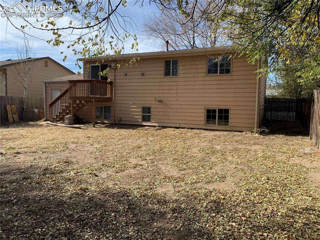 1057 Peterson Road Colorado Springs, CO 80915 - Photo 8 of 32 Rear view of house featuring a fenced backyard, a wooden deck, and stairs