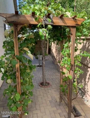 a backyard of a house with table and chairs under an umbrella
