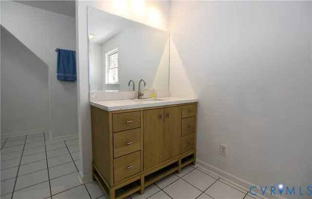 a living room with a bed and a wooden floor