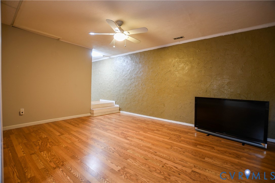 153 Deer Trail Aylett, VA 23009 - Photo 23 of 50 a view of an empty room with wooden floor and a fan