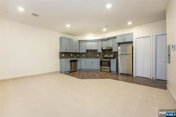 a large kitchen with a refrigerator and a stove top oven