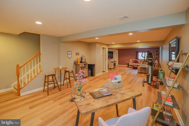 a living room with furniture kitchen view and a wooden floor