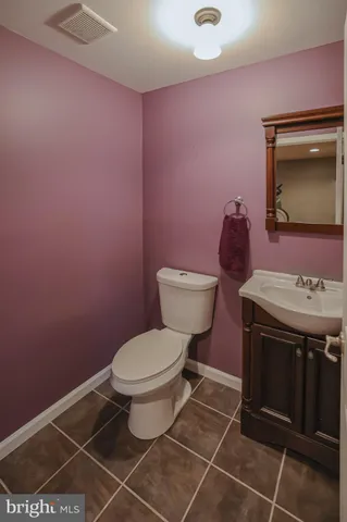 a bathroom with a toilet a sink and mirror