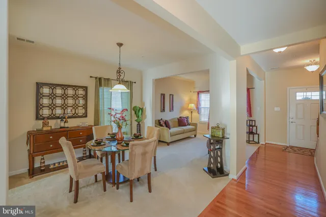 a living room with furniture a chandelier a mirror and a flat screen tv