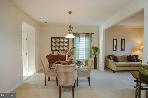 a dining room with furniture a chandelier and window