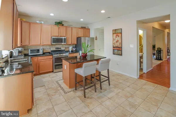 a kitchen with kitchen island granite countertop lots of counter top space and stainless steel appliances