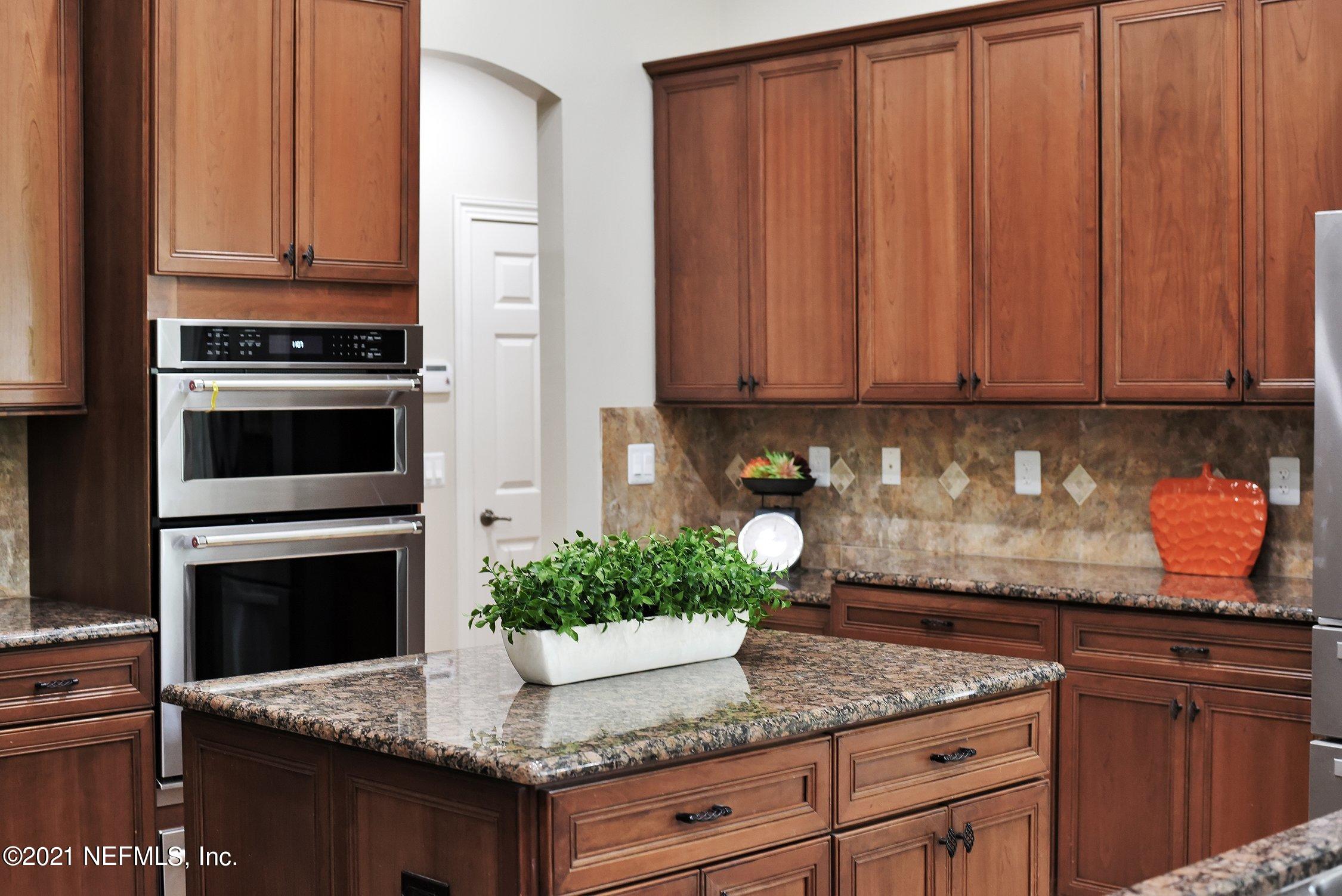 142 Marshall Creek Drive St. Augustine, FL 32095 - Photo 36 of 176 a kitchen with granite countertop stainless steel appliances a stove a microwave and sink
