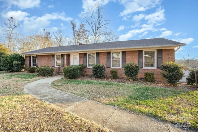 a front view of house with yard and trees around