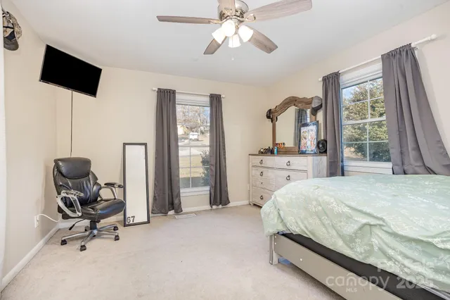a bedroom with a bed a flat screen tv and balcony