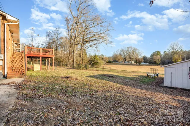 a view of a yard with wooden fence